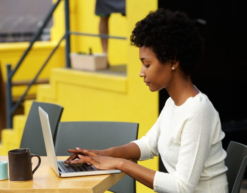 attractive-young-woman-using-laptop-outside-P9RLFGU@2x-830x647